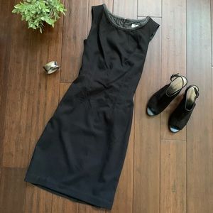 Sleeveless black dress with faux leather accent